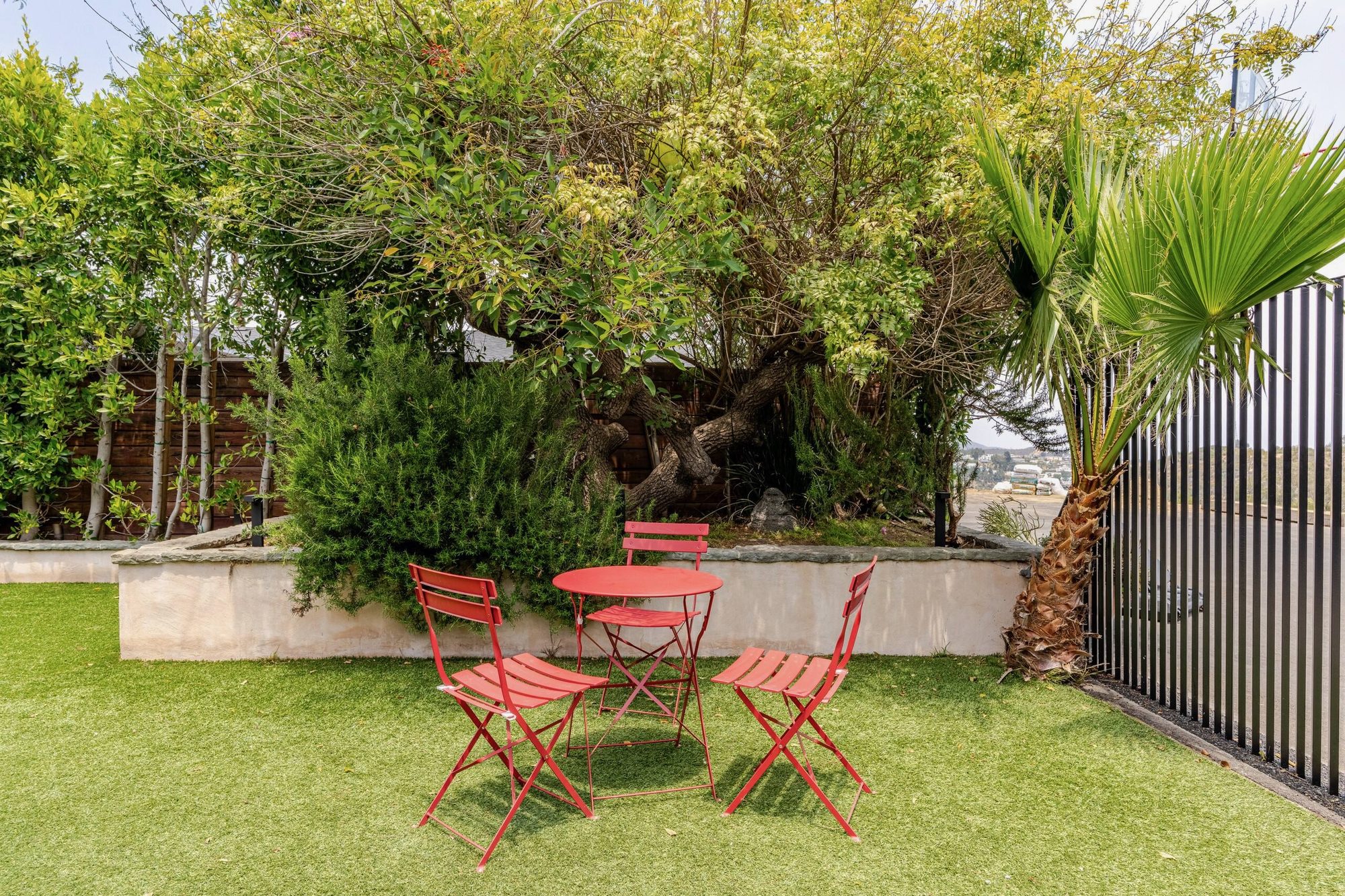 Backyard lawn with adirondack chairs and red bistro table