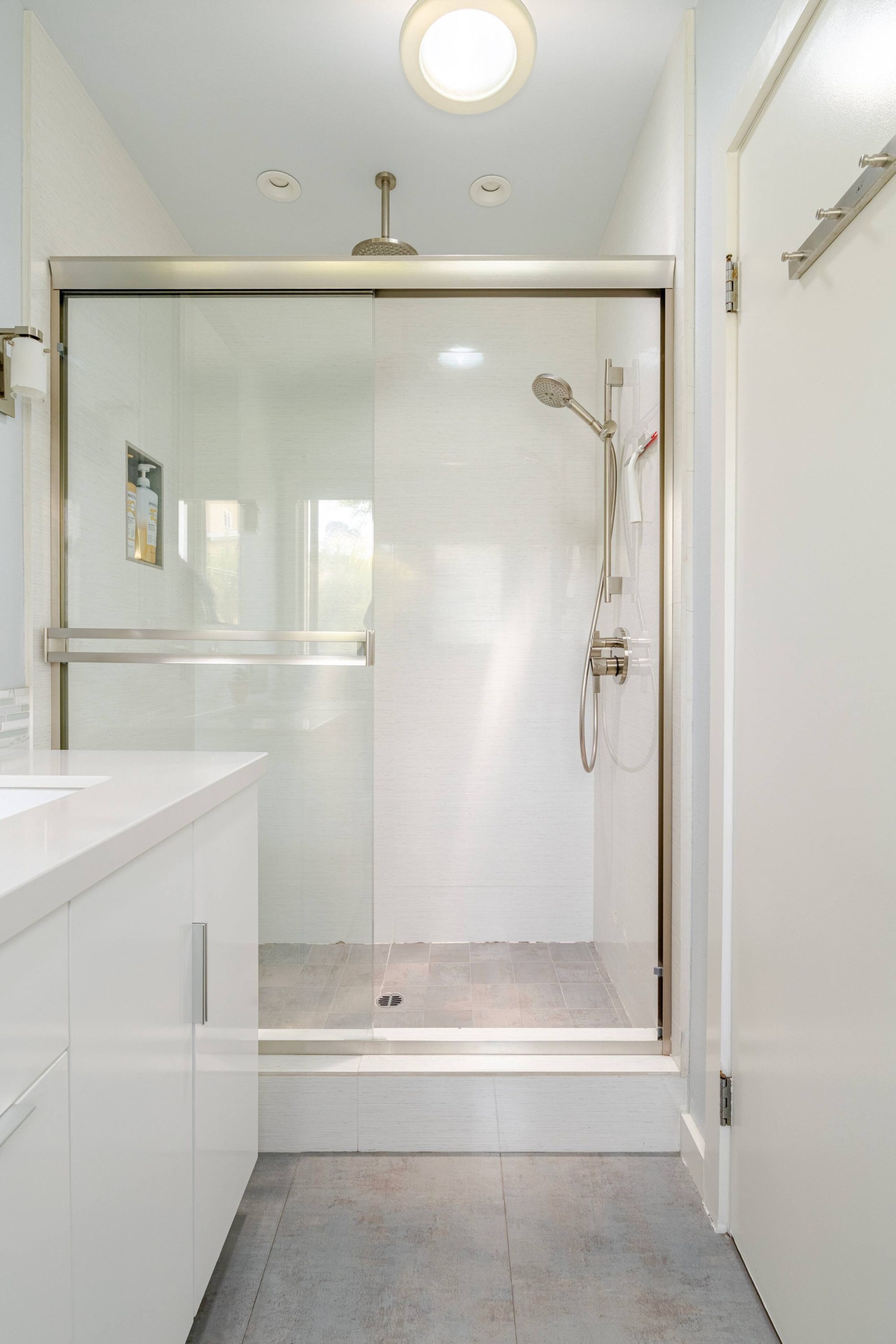 Walk-in glass shower with rainfall showerhead and handheld sprayer