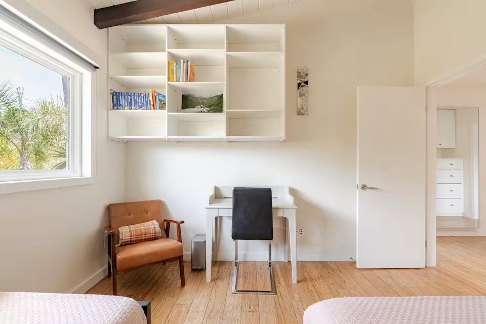 Built-in bedroom shelving with books beside a doorway to an ensuite bathroom