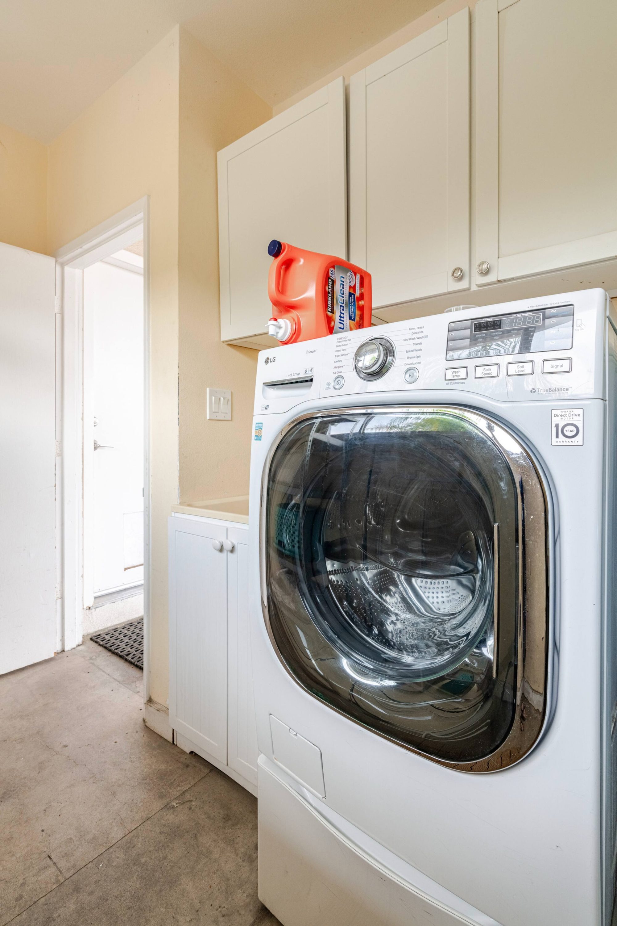 Front-loading washing machine beside the back door of the laundry room