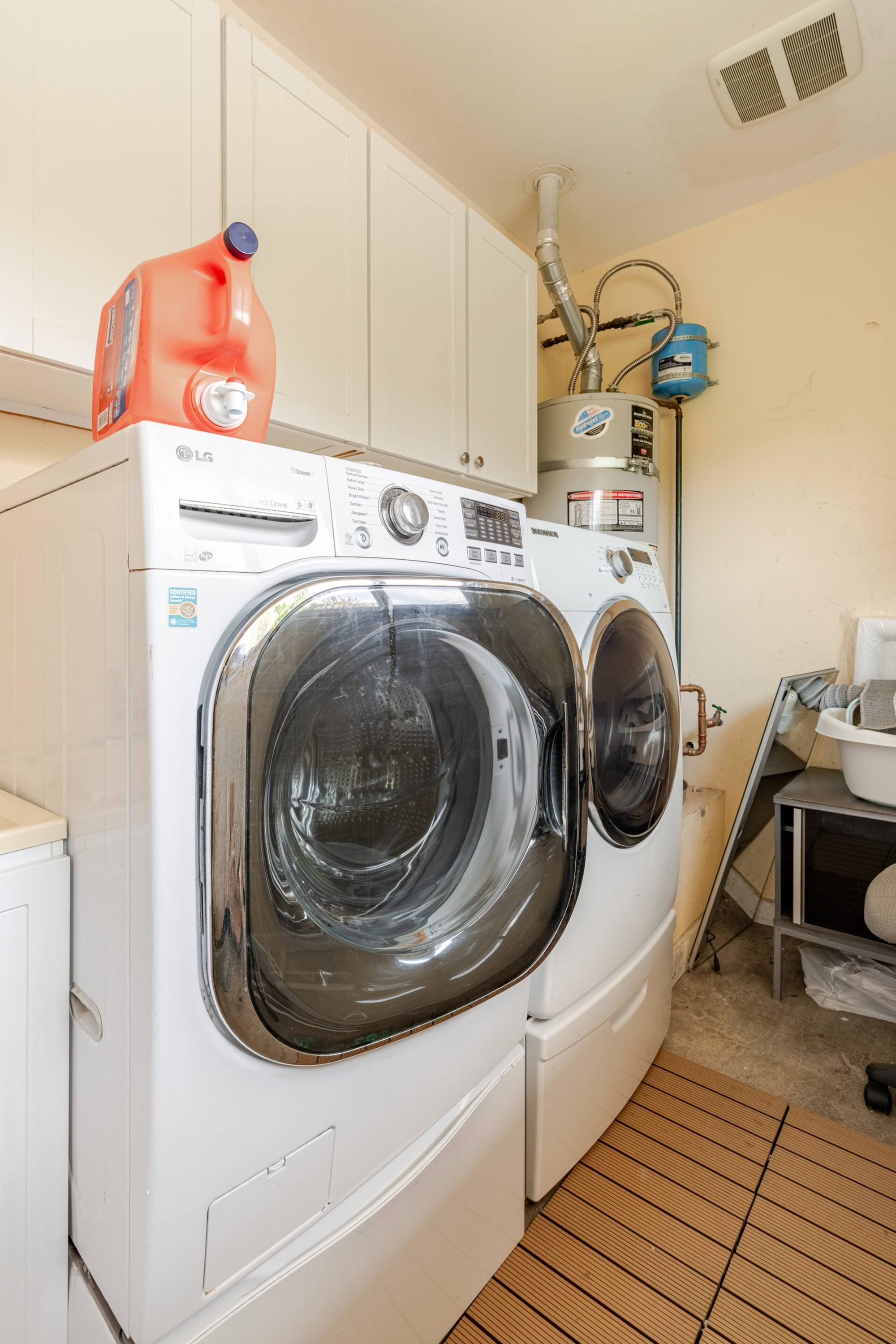 Washer and dryer in a dedicated laundry room with storage cabinets