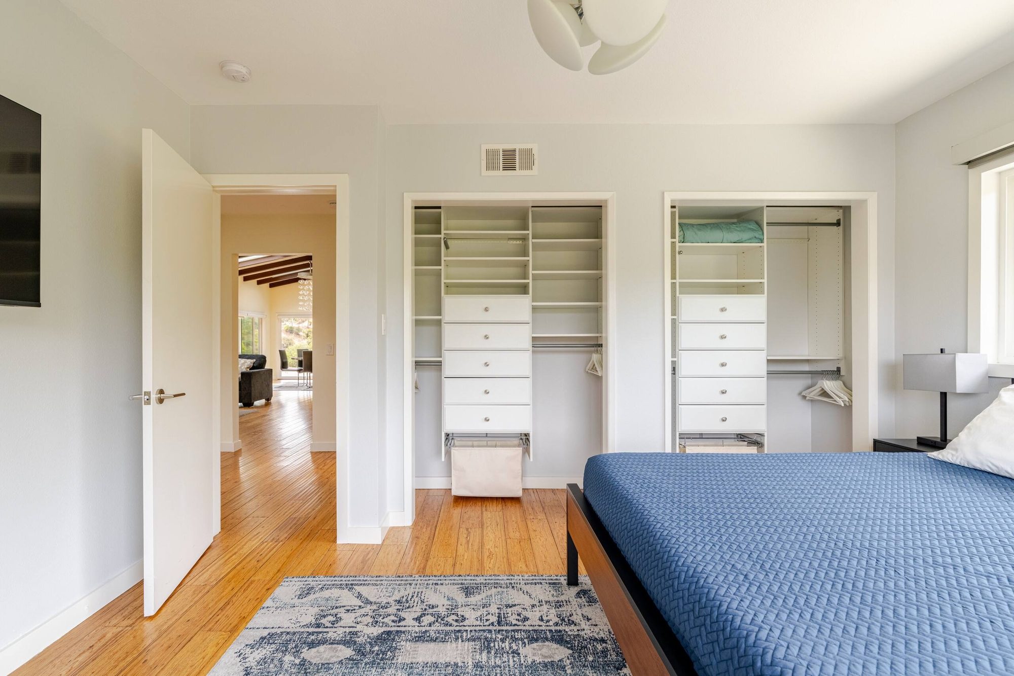 Two built-in closets with drawers and hanging rods in the second bedroom